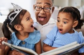 Grandparent reading a storybook to his two young grandchildren